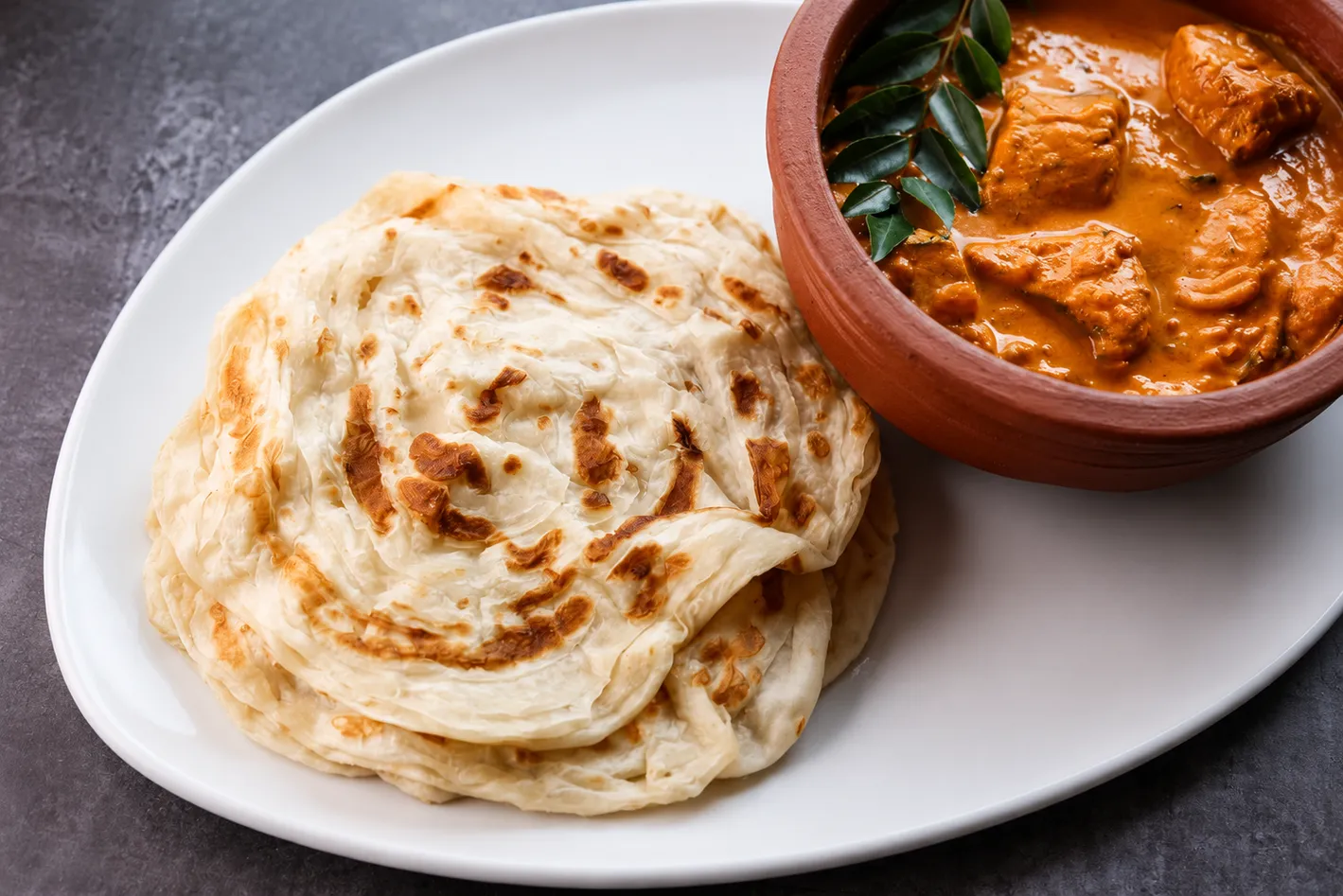 Kerala Chicken Curry with Porotta at Kerala Palace Restaurant Calgary — flaky porotta with spiced Kerala chicken curry